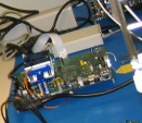 A RISCWatch processor probe seen in an engineering lab photo next to an early Xbox 360 board.